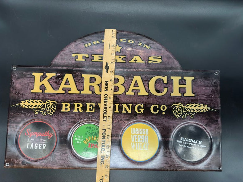 Decorative sign with 'Karbach' branded with ruler for height scale on a faux wood background.