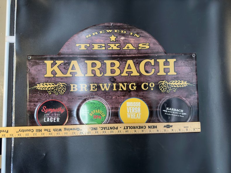Karbach Brewing Co. sign with a ruler for width scale on a faux wood background